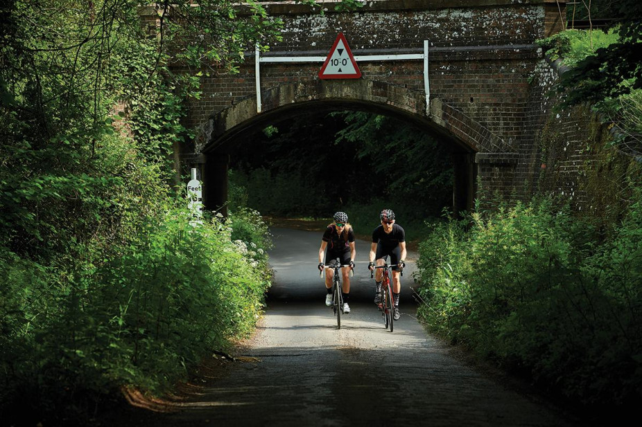 Two cyclists riding through the scenic Ashdown forest, England