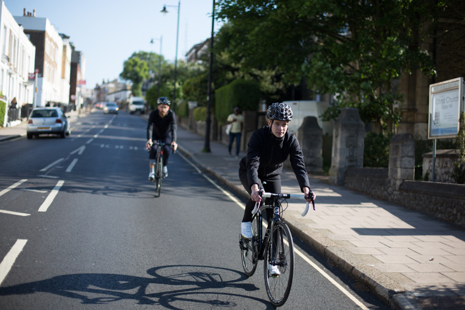 Two cyclists descending down a busy public road riding their Orro Bikes