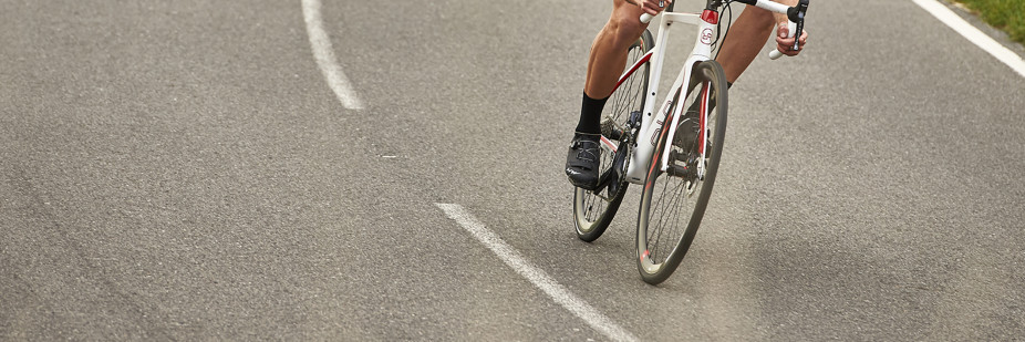 Cyclist riding his Orro carbon road bike through a windy road