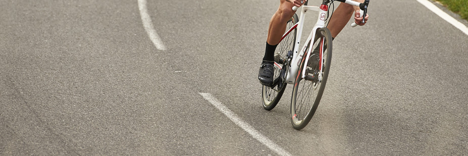 Cyclist riding his Orro carbon road bike through a windy road